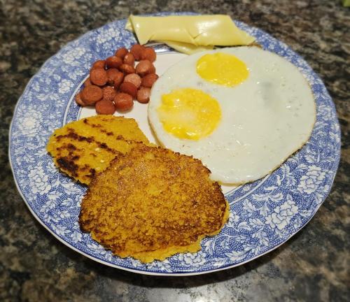 a blue and white plate with eggs and fried foods at Hostal Posada Turística El Bejuco in Leticia