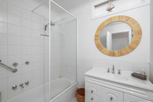 a white bathroom with a sink and a mirror at The Bach at Ventnor in Ventnor