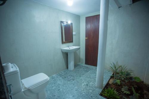 a bathroom with a toilet and a sink and a mirror at Nasha Lanka House in Koggala