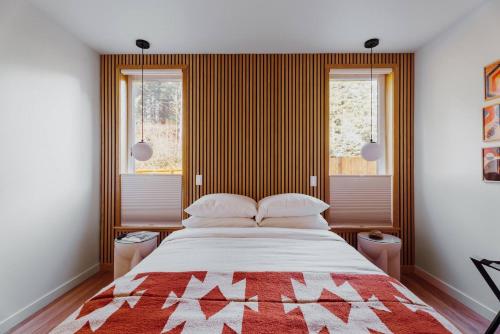 a bedroom with a large bed and two windows at Camp Alpine in Packwood