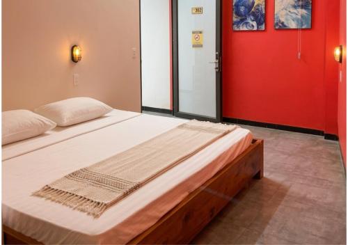 a bed in a room with a red door at Brotherhood Loop Hostel Station in Làng Lap