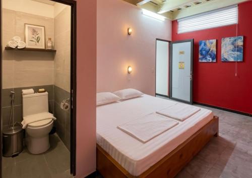 a small bedroom with a bed and a toilet at Brotherhood Loop Hostel Station in Làng Lap