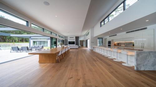a large room with wooden floors and large windows at Launa Killcare Heights in Killcare