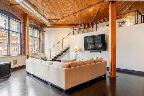 a living room with a couch and a flat screen tv at Massive Downtown Seattle Condo - Free Parking! in Seattle