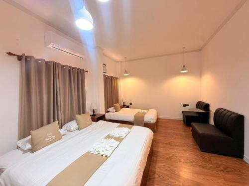 a hotel room with two beds and a couch at Sunin Hotel Dondet Riverside in Don Det