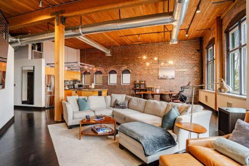 a living room filled with furniture and a brick wall at Massive Downtown Seattle Condo - Free Parking! in Seattle