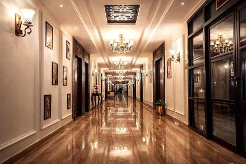a hallway of a building with wooden floors and a chandelier at Best Western Faisalabad in Faisalabad