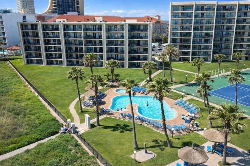 an aerial view of a resort pool with palm trees at Resort like super heated pool & direct beach front in South Padre Island