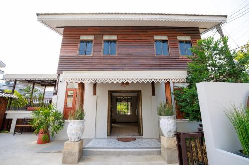 a wooden house with a door in front of it at Cozy Lanna Hotel in Chiang Mai