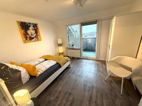 a bedroom with a bed and a desk and a window at Über den Dächern Kemptens mit Panoramablick in Kempten