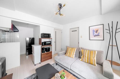 ein Wohnzimmer mit Sofa und Fernseher in der Unterkunft RT2 103 rk in Sapporo