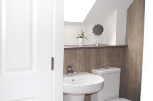 a bathroom with a white toilet and a sink at The Willows in Beauly