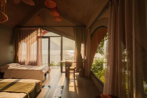 a hotel room with two beds and a balcony at Maida Lodge in Hòa Bình