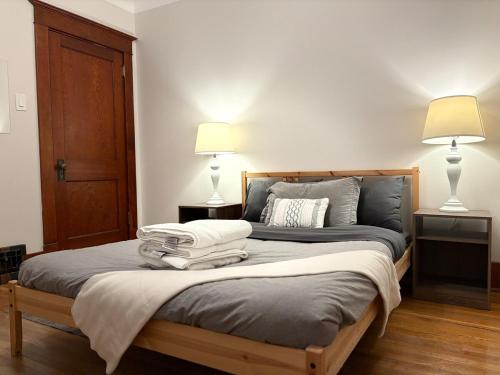 a bedroom with a large bed with two lamps on it at Restly an Elegant Home by Whyte Ave in Edmonton