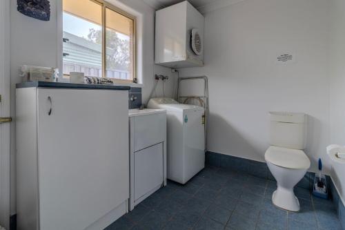 a small bathroom with a toilet and a sink at Holiday on the Water in Sussex Inlet