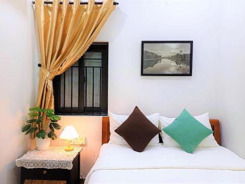 a bedroom with a bed and a window at PHỐ XANH hotel - STAY 24H in Hoi An