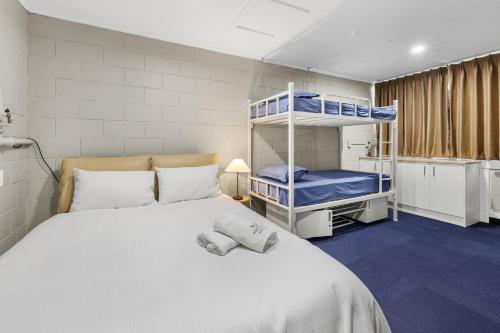 a bedroom with a bed with two bunk beds at FlyingPig Backpacker Rotorua in Rotorua
