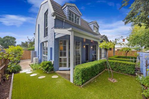 a blue house with a yard with green grass at La Maison Bleue in Ballarat