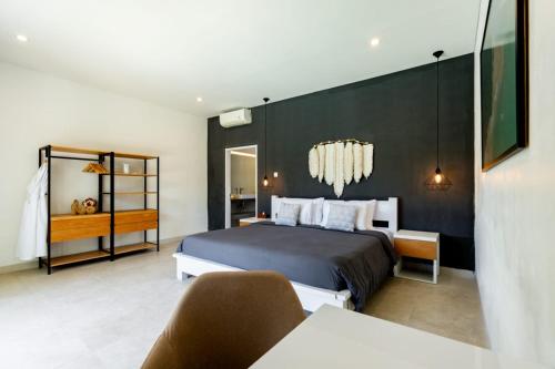 a bedroom with a bed and a black wall at Luxury 5BR Villa with Rooftop BBQ Pool 500M to Beach in Canggu