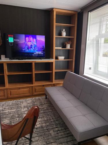a living room with a couch and a flat screen tv at Karula Stay - 2 Bedroom City Centre Apartment in Antsla
