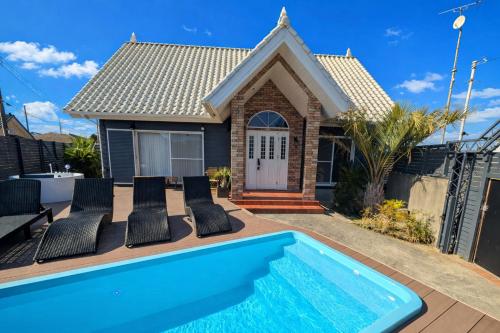 a villa with a swimming pool in front of a house at The No.10 Sunrise Beach 九十九里 in Kujukuri