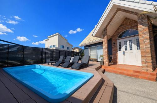 a backyard with a swimming pool and a house at The No.10 Sunrise Beach 九十九里 in Kujukuri