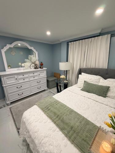 a bedroom with a white bed and a dresser at Private Paradise bk in Brooklyn