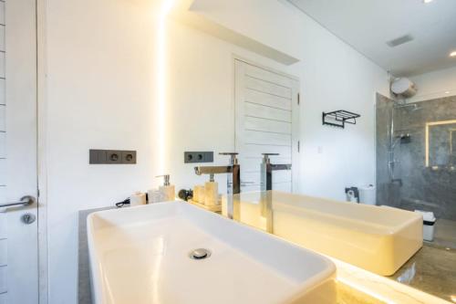 a white bathroom with a tub and a sink at Luxury 5BR Villa with Rooftop BBQ Pool 500M to Beach in Canggu