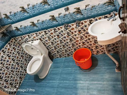 a bathroom with a toilet and sink and ducks on the wall at ARMANI Villa Nagapattinam in Sikkil