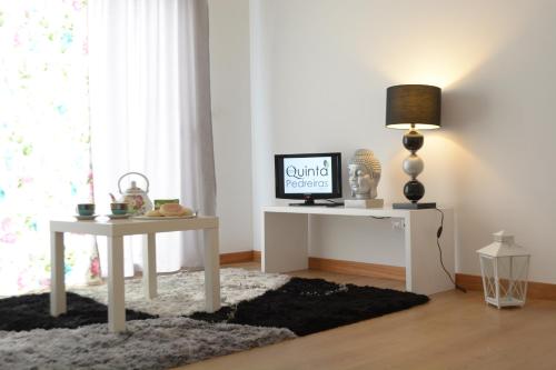 a living room with a white table and a tv at Quinta das Pedreiras in Pico da Pedra