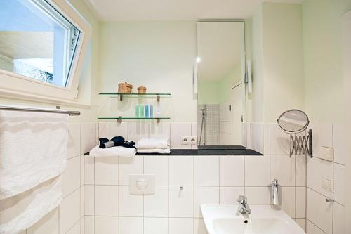 a white bathroom with a sink and a mirror at Architektenwohnung in der Sternschanze in Hamburg