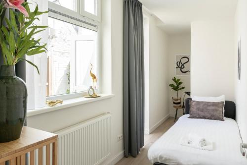 a living room with a bed and a window at Spacious Family Stay Eindhoven, Garden & Kitchen in Eindhoven