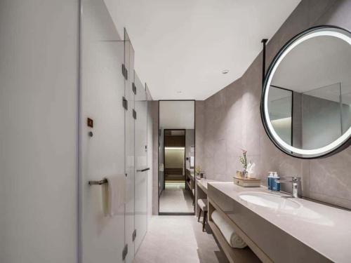 a bathroom with a sink and a mirror at Maison New Century Ninghai Railway Station in Ninghai