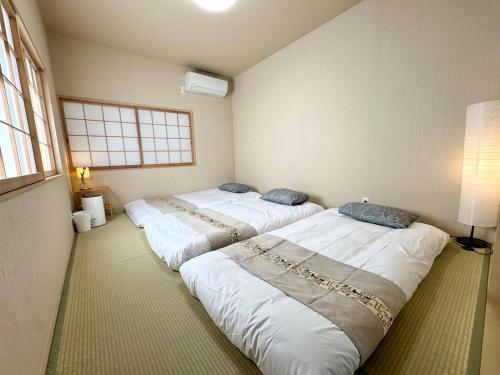 three beds are lined up in a room at 楽途居 in Osaka