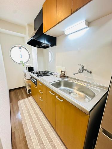 a kitchen with a sink and a stove at 楽途居 in Osaka