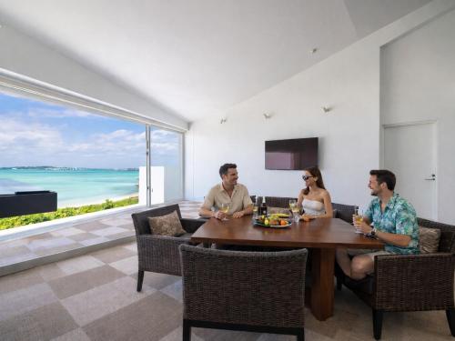 a group of people sitting around a table in a living room at VOYAN Resort MiyakojimaーAZOMARE アゾマーレ in Miyako-jima