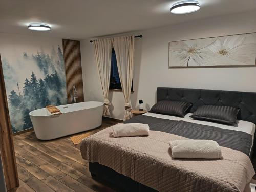 a bedroom with two beds and a bath tub at Vrh house in Ravna Gora