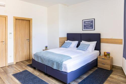 a bedroom with a large bed with a blue headboard at Apartments R Sport boutique with free Parking in Sarajevo