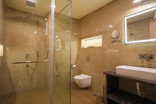 a bathroom with a shower and a toilet and a sink at Town Square Suites in Hyderabad