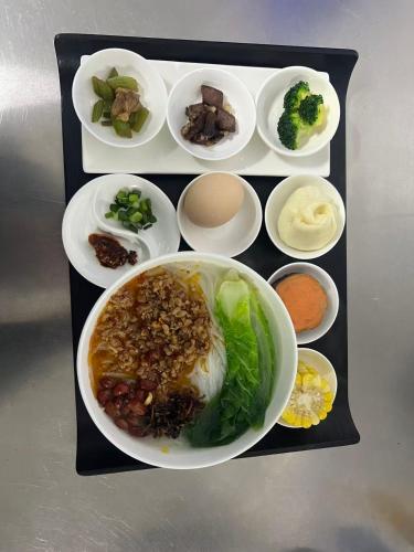 a tray with a bowl of food with different foods at Dali Shuanglang Erhai Lake in Dali Shuanglang