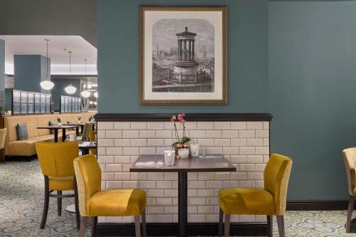 a dining room with a table and chairs at Hilton Edinburgh Carlton in Edinburgh