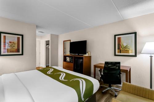 a hotel room with a bed and a desk and a tv at Quality Inn Jessup - Columbia South Near Fort Meade in Jessup