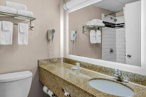 a bathroom with a sink and a toilet and a mirror at Quality Inn Jessup - Columbia South Near Fort Meade in Jessup