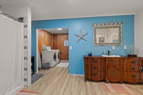 a bathroom with a sink and a mirror on a blue wall at 4-Bedroom Chateau in Southern Washington- Luxurious Retreat with Pond & Creek in Amboy