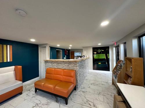 a lobby with a leather chair and a bar at Rodeway Inn Jonesboro - Atlanta South in Jonesboro