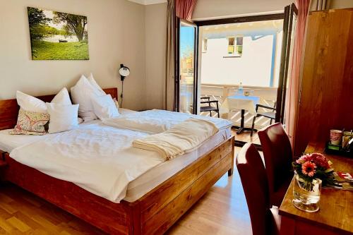 a bedroom with a large bed and a table with chairs at Hotel Garni Möwe in Tutzing