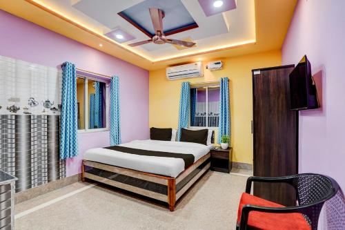 a bedroom with a bed and a ceiling fan at Hotel O Puri Seaview Formerly Sea Star in Puri