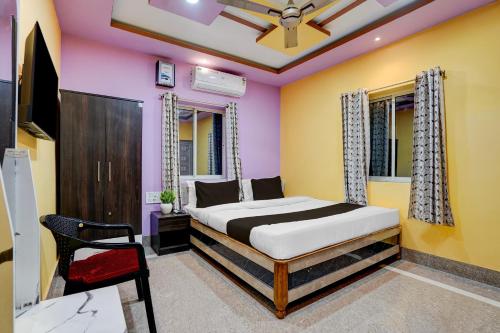 a bedroom with yellow and pink walls and a bed at Hotel O Puri Seaview Formerly Sea Star in Puri