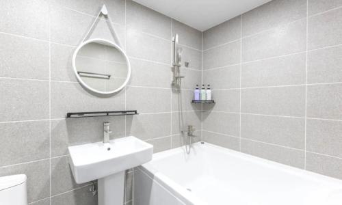 a white bathroom with a sink and a mirror at Gimcheon Sweet Hotel in Kimch'ŏn