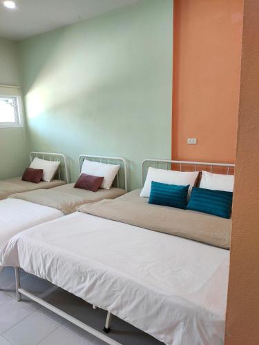 three beds in a room with blue pillows on them at Banyai Pool Villa Chiang Khan in Loei